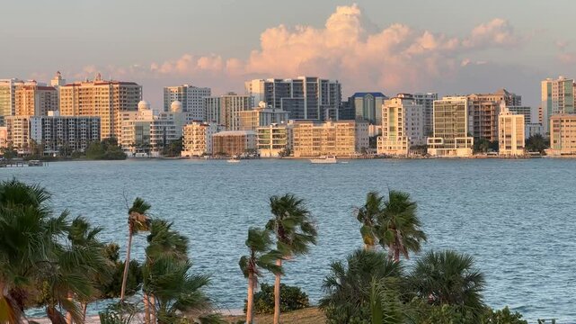 Downtown Sarasota Florida with Golden Gate Point from John Ringling Causeway bridge, yachts, palms and hotels, pink skies during beautiful Florida sunset