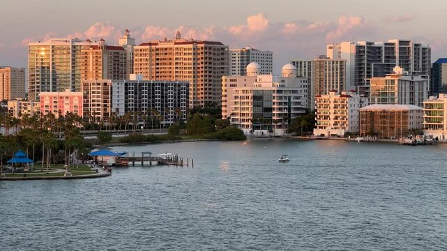 Downtown Sarasota Florida with Golden Gate Point from John Ringling Causeway bridge, yachts, palms and hotels, pink skies during beautiful Florida sunset