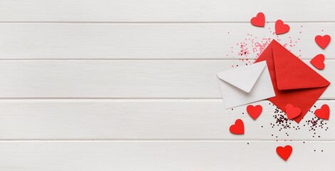 Envelopes, hearts and confetti on white wooden background with space for text. Valentine's Day celebration