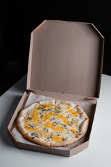 pizza four cheeses in a cardboard box. Pizza delivery