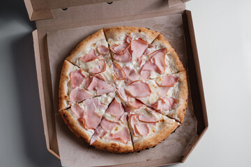 pizza with ham in a cardboard box. Pizza delivery