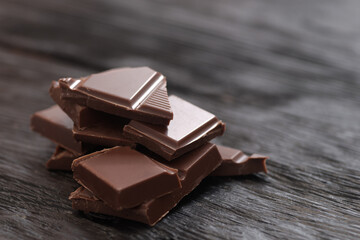 Broken dark chocolate on a wooden table