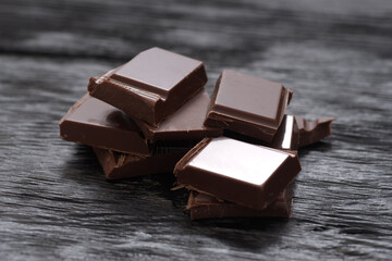 Broken dark chocolate on a wooden table