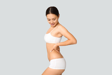 Obraz premium Slim young woman in underwear on light background. Weight loss concept