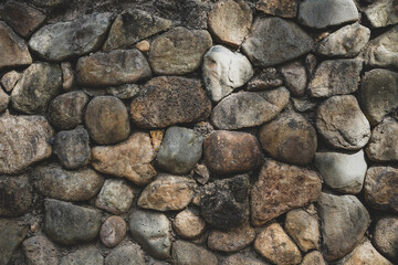 Embossed pebble wall for abstract background and texture for interior or exterior design. Beautiful patterns, space for work, banner, wallpaper close up.