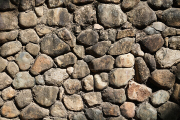 Embossed pebble wall for abstract background and texture for interior or exterior design. Beautiful patterns, space for work, banner, wallpaper close up.