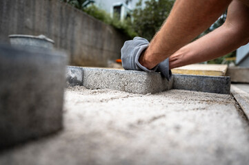 Worker laying concrete pavers for a patio