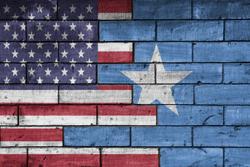 colourful painted big flag of united states of america and flag of somalia on a massive old brick...