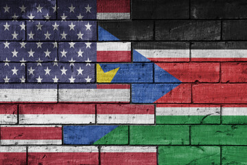 colourful painted big flag of united states of america and flag of south sudan on a massive old...