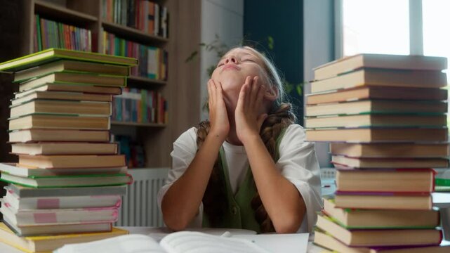Bored annoyed angry suffering Caucasian little girl school child kid schoolgirl learning hard schoolwork books too much homework struggle education problems mental burnout exhaustion indoors library
