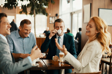 Diverse business people having meeting in modern cafe