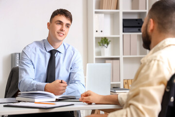 Young lawyer working with client in wheelchair at office