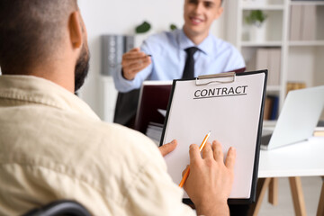 Fototapeta premium Young man with contract at lawyer's office, closeup