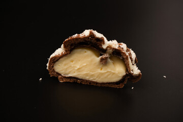 Profiteroles with coconut cream on a black background.