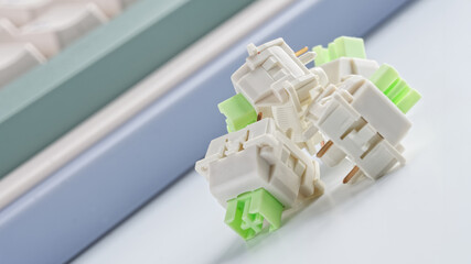 Mechanical switches for a modern computer keyboard next to the keyboard on a light background....