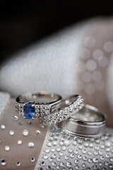 Elegant silver and sapphire wedding rings in front of bridal shoes