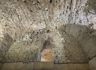 Split, Croatia - Split, Croatia - July 1, 2024: Historic Diocletian Cellars and palace. Open connecting niche in wall full of cracks, holes. Bowed ceiling in front.