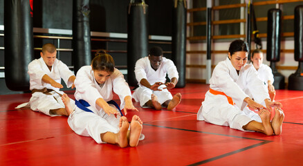 Athletes in kimono doing abdominal exercise