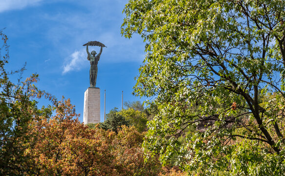Budapest,Hungary,August 29,2022. The Statue of Liberty dominates the city from the top of the hill, it is an iconic symbol of the capital. On a beautiful summer day the treetops frame the pedestal.