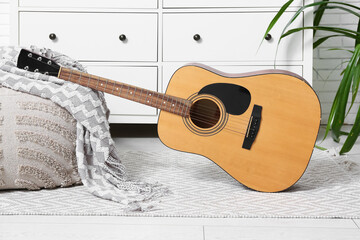 Modern acoustic guitar on floor in stylish living room