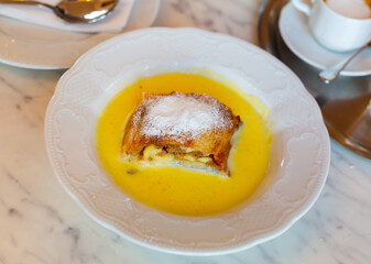 Slice of delicious Viennese strudel with aromatic apple and cinnamon filling traditionally served with vanilla sauce. Authentic cuisine