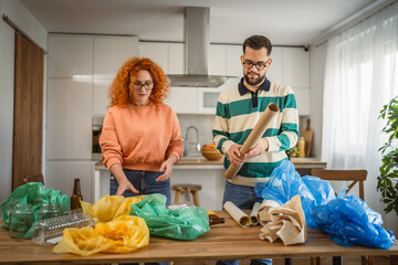 man and woman recycle at home sorting waste plastic paper and glass
