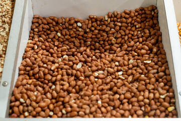 Peanuts in a crate for sale at a stand. The most consumed legume in the world is rich in good fats,...