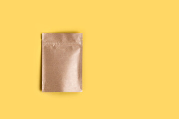 Kraft paper empty bags isolated in brown card box mock up on yellow background. Eco friendly pack with zipper, roasted specialty coffee beans, tea, snack, trendy concept. top view, flat lay