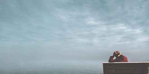 Unhappy single woman sitting on bench, looking at distant sea or seascape horizon. Lonely young woman missing someone, desire or hope to go far away concept idea. Time to go, say goodbye or good bye.	