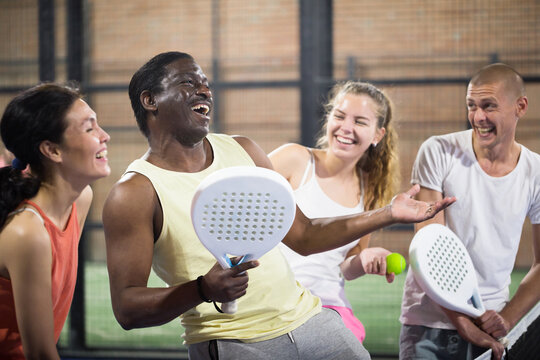 Cheerful team of men and women after playing padel on the tennis court