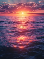 A mesmerizing sunset over a tranquil ocean. The vibrant hues of pink and orange reflect on the water's surface. Ideal for backgrounds, wallpapers, or nature-themed projects.
