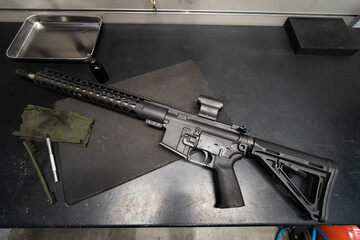 Rifle Ar 15 with red dot in the gunsmith's workshop on the table, close-up photo.