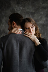 Sad embrace of lovers, a man stands with his back to the camera, women's hands are visible