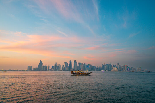 Fototapeta doha qatar skyscrapers by the sea at sunset and tour ship
