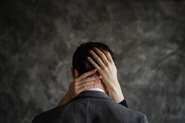 Woman's hands in man's hair captured on textured gray background