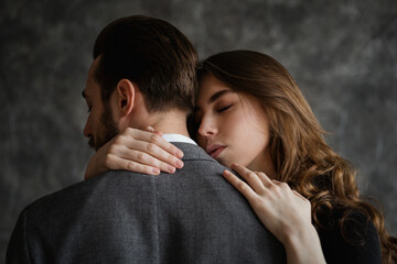Tender embrace of lovers, a man stands with his back to the camera, women's hands are visible