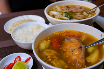 Finnish fish soup with red fish with spices and fresh dill on a dark stone background. Top view with copy space.. Fish soup with red fish