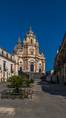 Obraz premium The central square of Ragusa Ibla with the majestic Duomo di San Giorgio. A stunning blend of Baroque architecture and Sicilian charm, capturing the essence of this UNESCO World Heritage site.