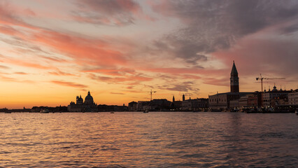Naklejka premium Sunset view of Venice skyline with St. Mark's Campanile and Santa Maria della Salute.