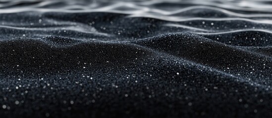 Dark, glittering surface with subtle waves.