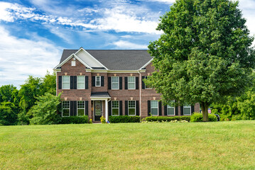 large, luxurious, brick two-story large family home with landscaping and huge green lawn. Landscape...