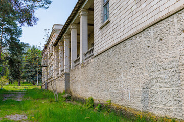 Historic stone building with columns surrounded by greenery