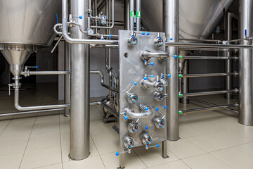 Industrial brewing equipment with stainless steel pipes and valves in brewery