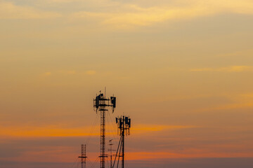 Silhouette of analog TV antenna mast pole on rooftop of high building, Telephone signal tower,...