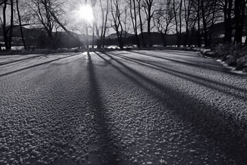 Ein gefrorener See mit Licht und Schatten im Gegenlicht der Sonne im Winter