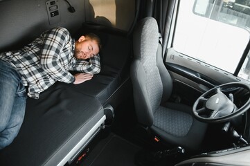 Truck driver sleeping in his cabin after working long routes overtime. Sleepy trucker taking a nap...
