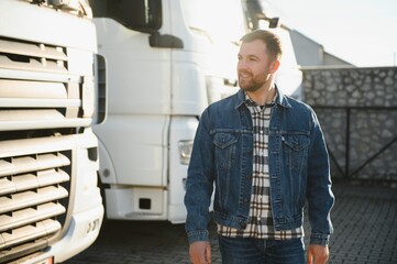 Portrait of young bearded trucker standing by his truck vehicle. Transportation service. Truck...