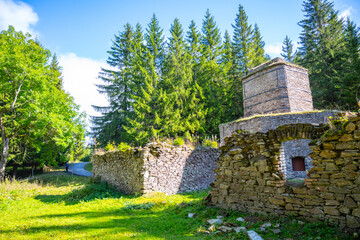 The historic remains of a lime kiln stand surrounded by lush greenery in the Ore Mountains near...