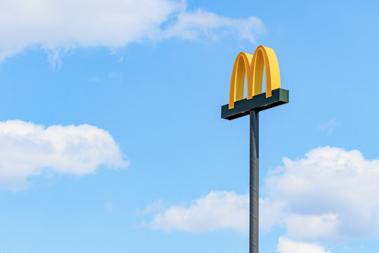 Tall mcdonald's sign against clear blue sky with white clouds. June 27, 2024 Balti Moldova
