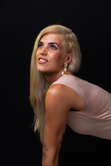 Fototapeta premium Beautiful blonde Caucasian model wearing a bodycon dress posing for a photo. Isolated on a black background. Salvador, Bahia.